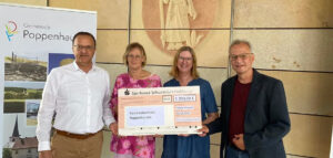 Bild von links nach rechts: Erster Bürgermeister Ludwig Nätscher überreicht im Rathaus Poppenhausen den Spendenscheck an Rosi Werner-Pinke, Petra Heuß und Ulrich Müller vom Büchereiteam der Familienbücherei.